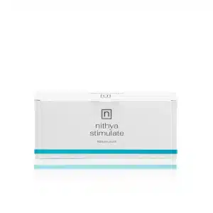 A rectangular white box with a minimalist design, featuring the text "NITHYA STIMULATE" and "Natural youth" on the front. A blue horizontal stripe accents the bottom edge of the box.