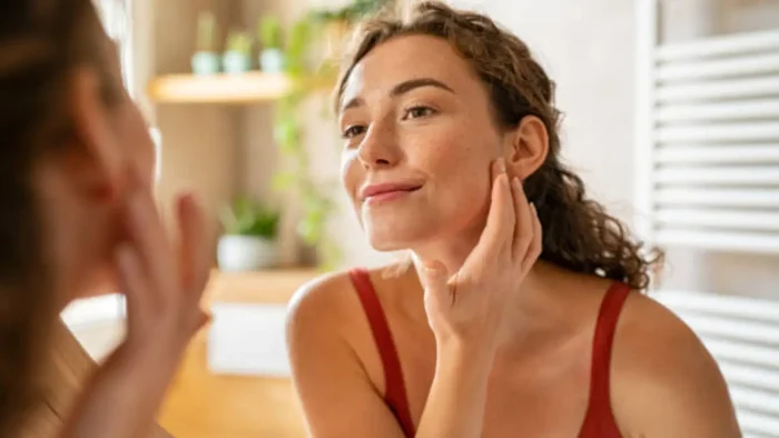 Woman looking at her face.